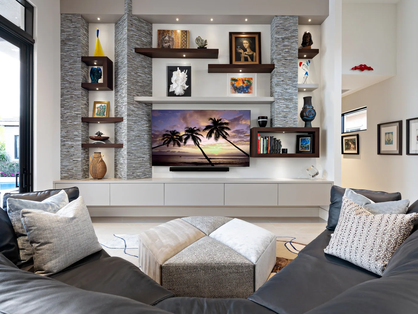 Custom media wall with floating walnut shelves, stone panel surrounds and lit display niches, Palm Beach County residence, Jupiter FL