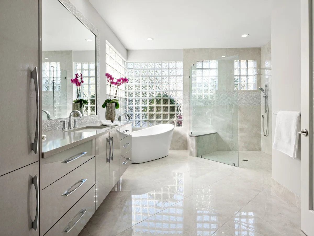 Custom primary bath vanity in grey with a freestanding tub and glass walk-in shower